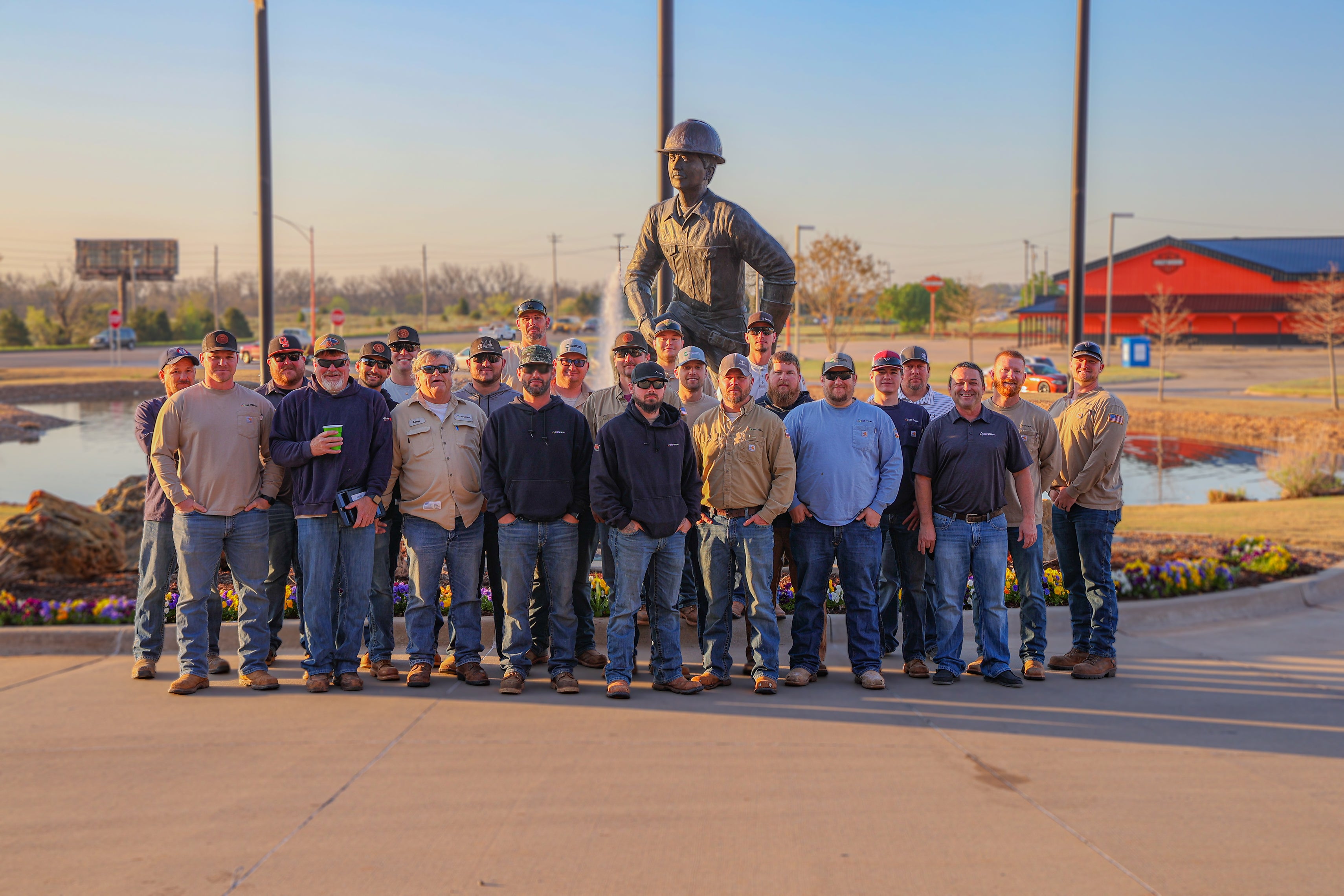 Central linemen pose in front of the lineman statue at Central Rural Electric Cooperative.